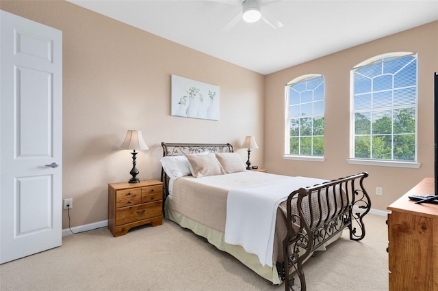 bedroom with light carpet, baseboards, and ceiling fan