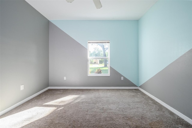 carpeted empty room featuring a ceiling fan and baseboards
