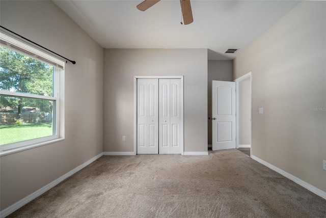 unfurnished bedroom with baseboards, a ceiling fan, a closet, and carpet