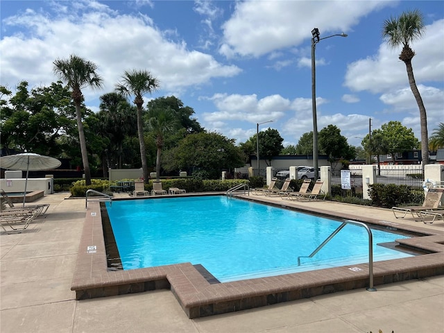pool with fence and a patio area