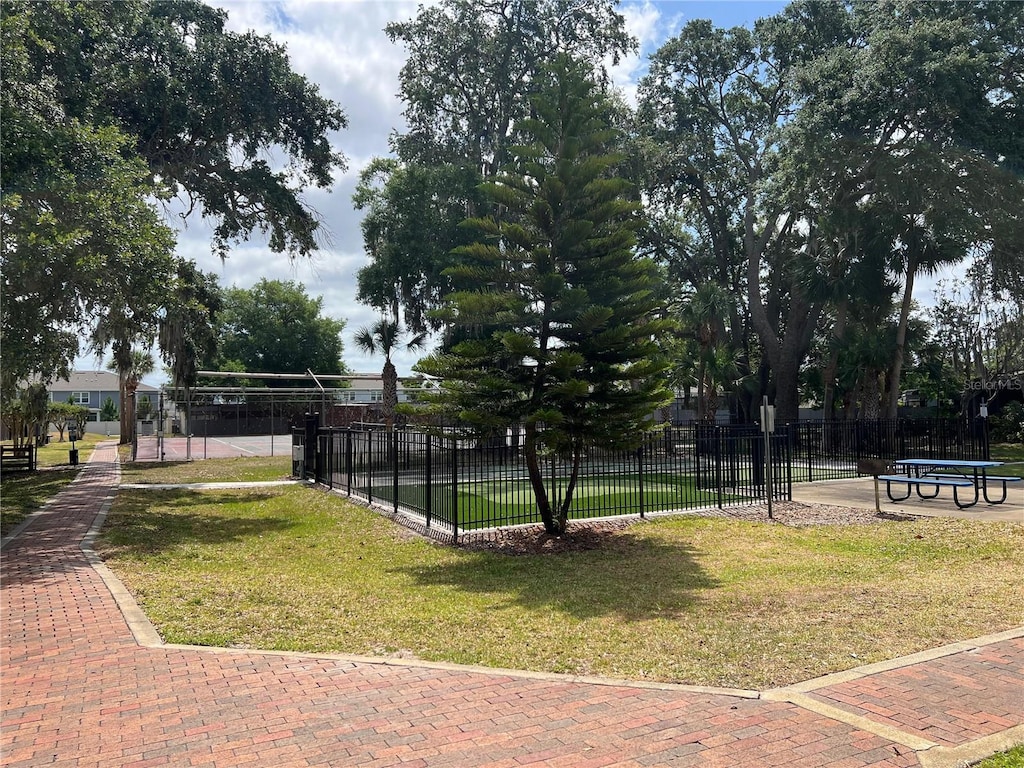 view of property's community with fence and a yard