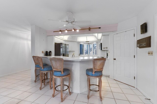 6330 Masters Blvd Unit N4, Orlando, FL 32819 - kitchen featuring stainless steel fridge with ice dispenser, a breakfast bar, white cabinetry, a peninsula, and light countertops