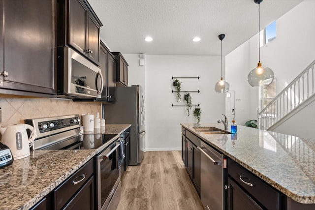 1801 Nice Ct, Kissimmee, FL 34747 - kitchen featuring a sink, appliances with stainless steel finishes, light wood-style floors, and stone counters
