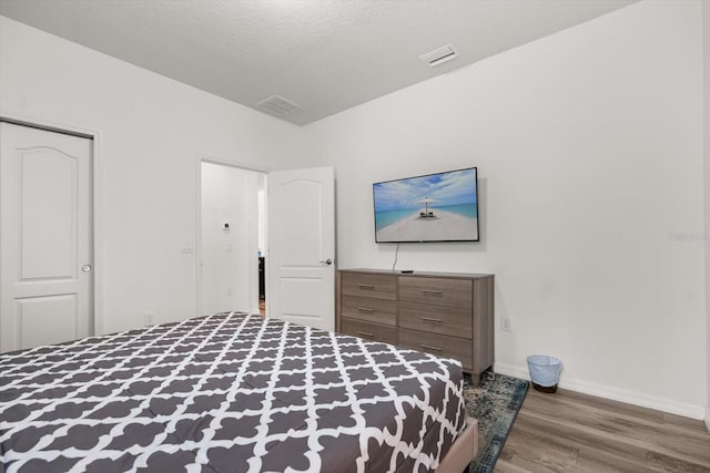 1801 Nice Ct, Kissimmee, FL 34747 - bedroom featuring baseboards, a textured ceiling, wood finished floors, and visible vents