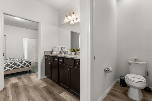 1801 Nice Ct, Kissimmee, FL 34747 - ensuite bathroom with wood finished floors, vanity, baseboards, toilet, and connected bathroom