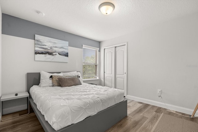 1801 Nice Ct, Kissimmee, FL 34747 - bedroom featuring a textured ceiling, baseboards, a closet, and wood finished floors