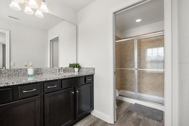 1801 Nice Ct, Kissimmee, FL 34747 - bathroom with visible vents, vanity, wood finished floors, toilet, and a stall shower