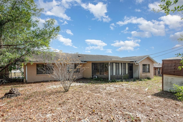 single story home featuring fence, stucco siding, and a sunroom