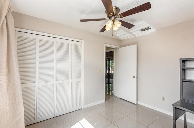 unfurnished bedroom with visible vents, baseboards, light tile patterned floors, and a closet