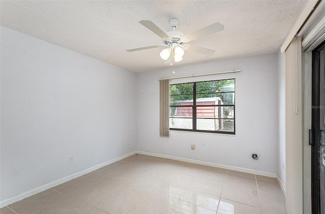 empty room featuring light tile patterned floors, baseboards, ceiling fan, and a textured ceiling