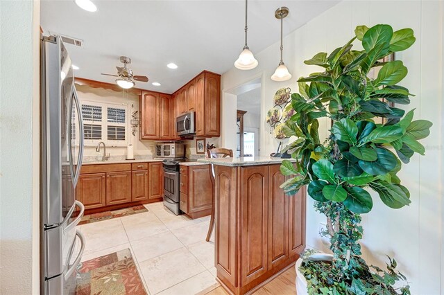 1208 Duke Way, Cocoa, FL 32922 - kitchen with a sink, appliances with stainless steel finishes, a ceiling fan, brown cabinetry, and hanging light fixtures
