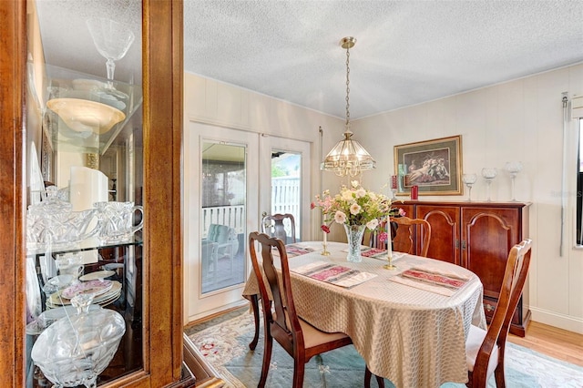 1208 Duke Way, Cocoa, FL 32922 - dining space with a decorative wall, a textured ceiling, an inviting chandelier, and wood finished floors