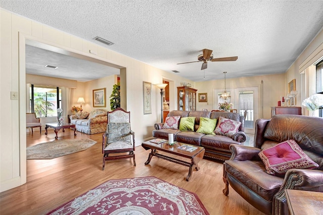 1208 Duke Way, Cocoa, FL 32922 - living room featuring light wood-style floors, visible vents, ceiling fan with notable chandelier, and a textured ceiling