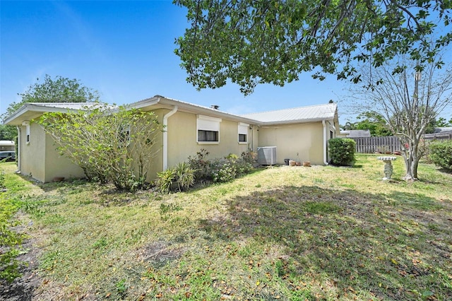 1208 Duke Way, Cocoa, FL 32922 - exterior space with fence, cooling unit, metal roof, a lawn, and stucco siding