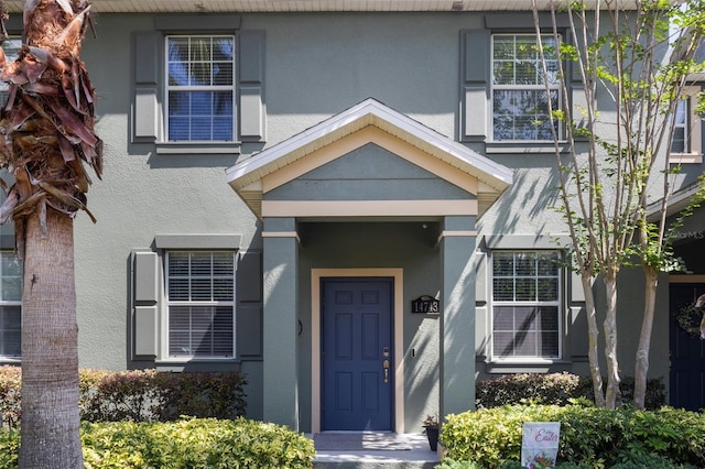 view of exterior entry featuring stucco siding