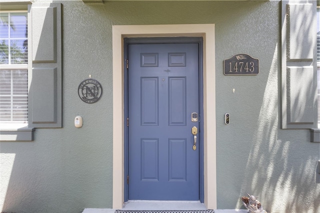 entrance to property featuring stucco siding