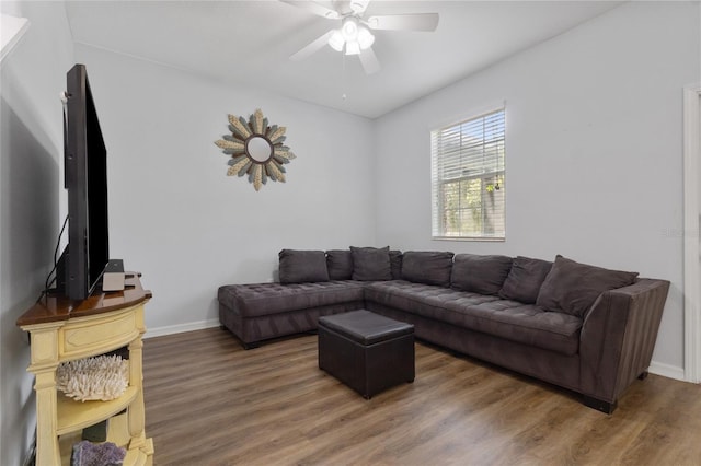 living area with baseboards, ceiling fan, and wood finished floors