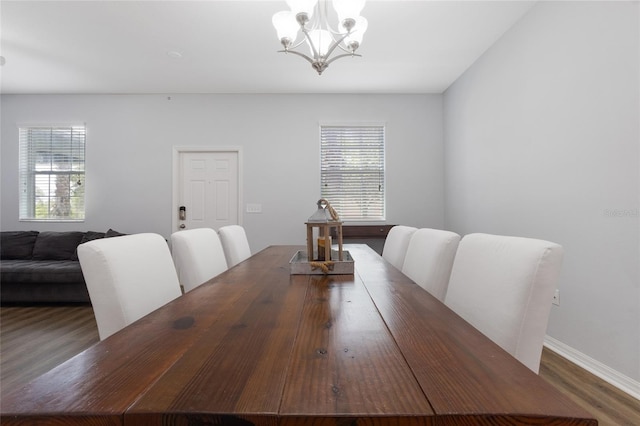 dining area with an inviting chandelier, baseboards, wood finished floors, and a wealth of natural light