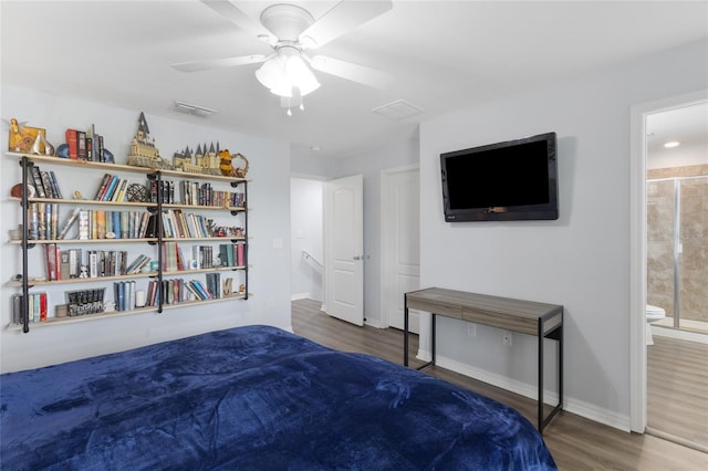 bedroom with visible vents, wood finished floors, baseboards, ceiling fan, and connected bathroom