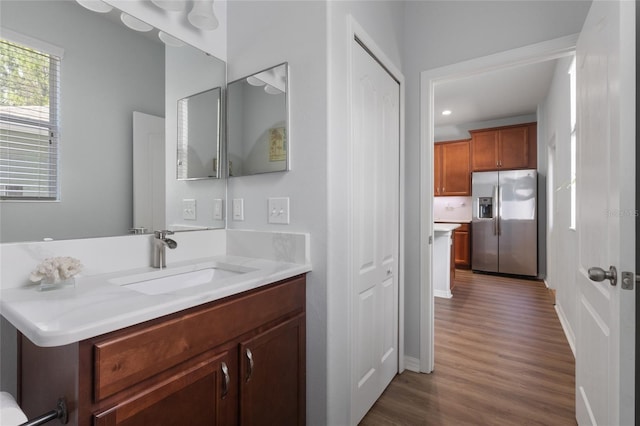 bathroom with vanity, recessed lighting, baseboards, and wood finished floors