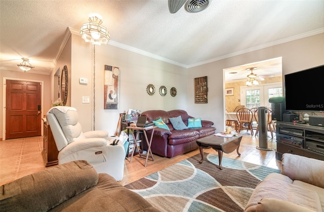 living room with light wood-style floors, a textured ceiling, a ceiling fan, visible vents, and ornamental molding