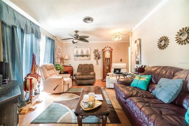 living room featuring crown molding, visible vents, light wood-style floors, a textured ceiling, and a ceiling fan
