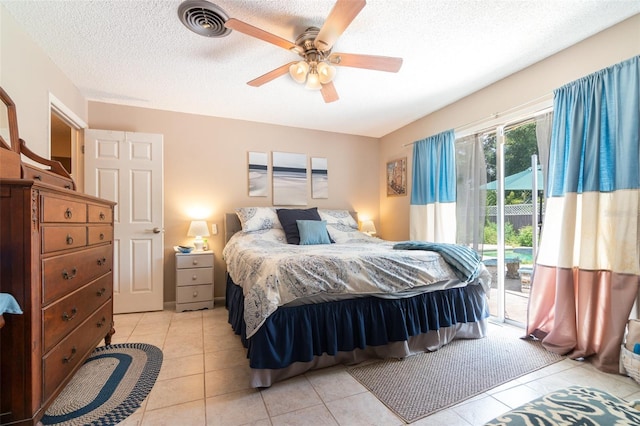 bedroom featuring a ceiling fan, a textured ceiling, visible vents, light tile patterned floors, and access to outside