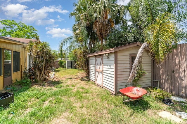 view of yard featuring an outbuilding, a fenced backyard, and a shed