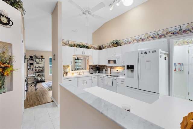 3661 Kingswood Ct, Clermont, FL 34711 - kitchen with white appliances, light countertops, high vaulted ceiling, a ceiling fan, and light tile patterned floors
