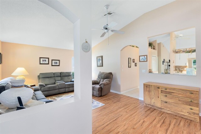3661 Kingswood Ct, Clermont, FL 34711 - living room featuring visible vents, a ceiling fan, light wood-style floors, baseboards, and arched walkways