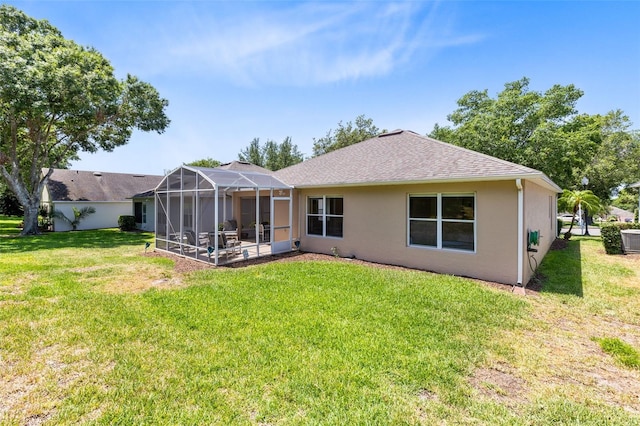 3661 Kingswood Ct, Clermont, FL 34711 - back of property with roof with shingles, central air condition unit, stucco siding, a lawn, and a lanai