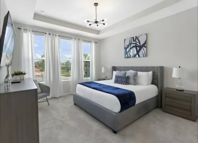 1929 Tropical Palms Cir, Kissimmee, FL 34747 - bedroom with light colored carpet, an inviting chandelier, and a raised ceiling