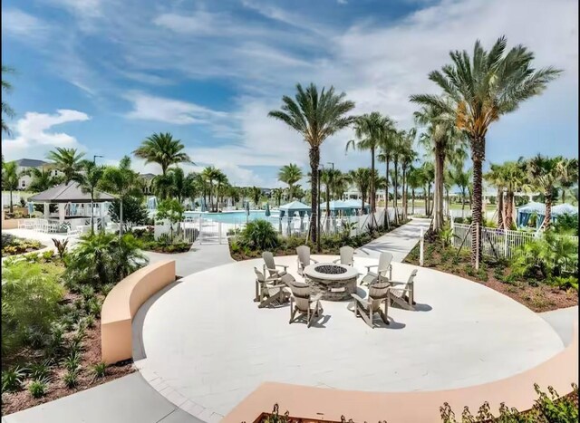 1929 Tropical Palms Cir, Kissimmee, FL 34747 - view of property's community featuring a patio, an outdoor fire pit, fence, and a pool
