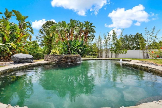 view of swimming pool featuring fence