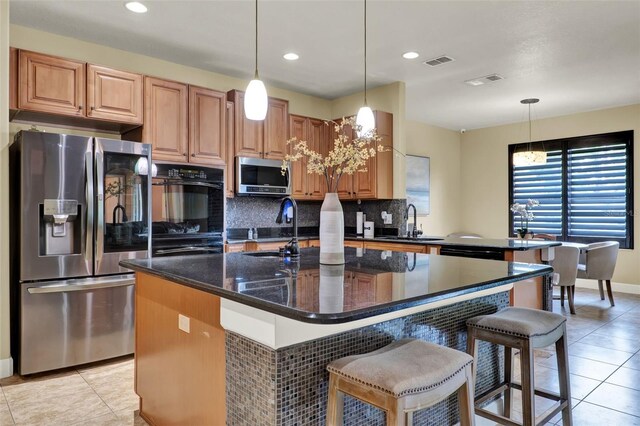 kitchen featuring a sink, appliances with stainless steel finishes, light tile patterned floors, and backsplash