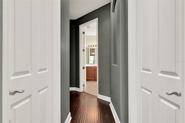 hall featuring baseboards and dark wood-style floors