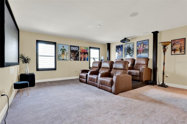 home theater room with baseboards, carpet, and decorative columns