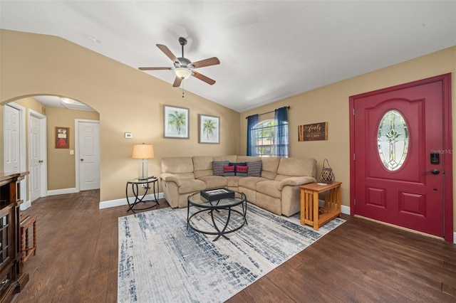living area featuring ceiling fan, arched walkways, vaulted ceiling, baseboards, and dark wood-type flooring