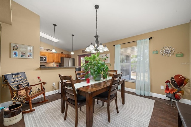dining room featuring baseboards, a chandelier, wood finished floors, and lofted ceiling
