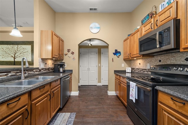 kitchen featuring dark countertops, appliances with stainless steel finishes, a sink, tasteful backsplash, and visible vents