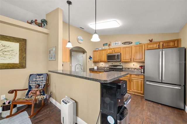 kitchen with visible vents, dark wood-type flooring, arched walkways, vaulted ceiling, and stainless steel appliances