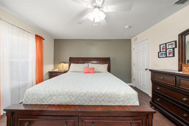 bedroom with dark wood-style flooring, ceiling fan, and visible vents
