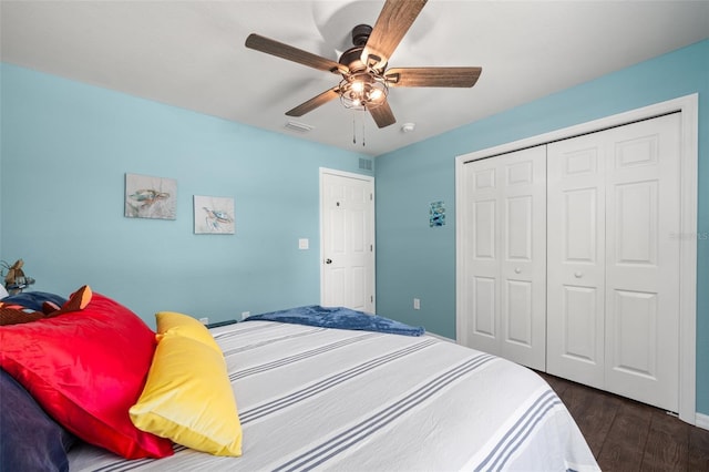 bedroom featuring ceiling fan, a closet, dark wood-style floors, and visible vents