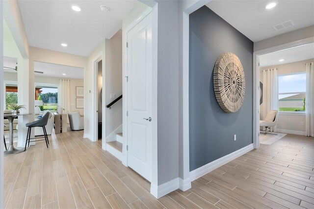 corridor featuring recessed lighting, baseboards, visible vents, and light wood-style floors