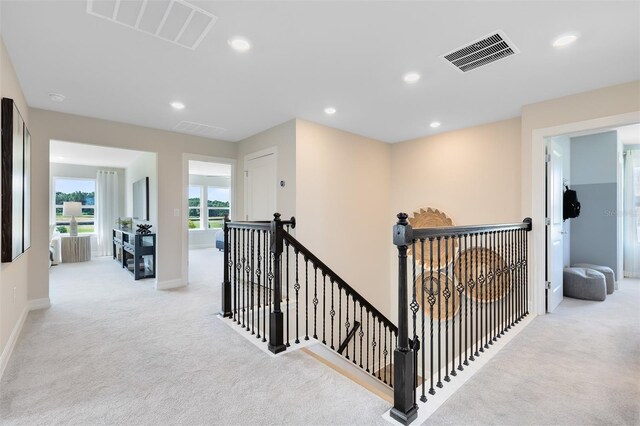 corridor featuring carpet flooring, an upstairs landing, and visible vents