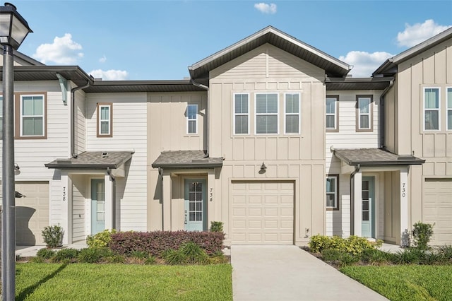 734 Longboat Dr, Davenport, FL 33896 - townhome / multi-family property featuring board and batten siding, driveway, a garage, and a front yard