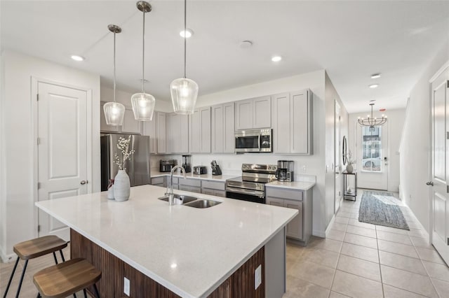 734 Longboat Dr, Davenport, FL 33896 - kitchen with appliances with stainless steel finishes, gray cabinetry, a sink, baseboards, and a kitchen bar