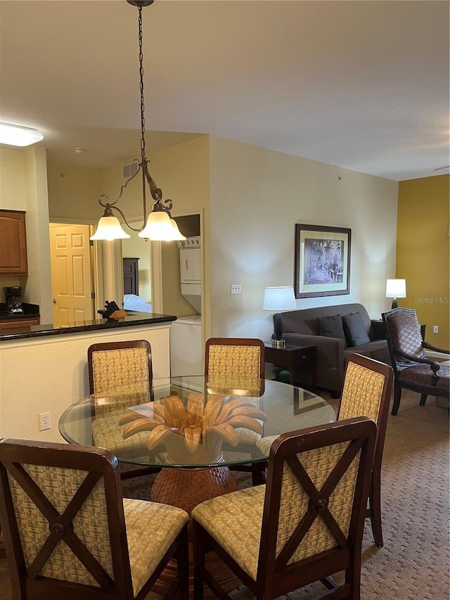 dining space with carpet floors, stacked washer / drying machine, and visible vents