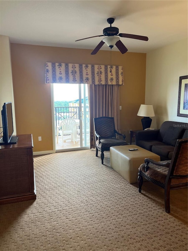 living area featuring carpet floors, ceiling fan, and baseboards