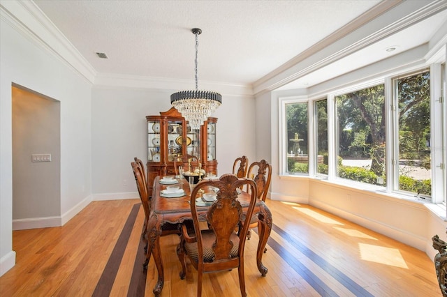 2828 Marquesas Ct, Windermere, FL 34786 - dining area with light wood-type flooring, a chandelier, ornamental molding, baseboards, and a textured ceiling